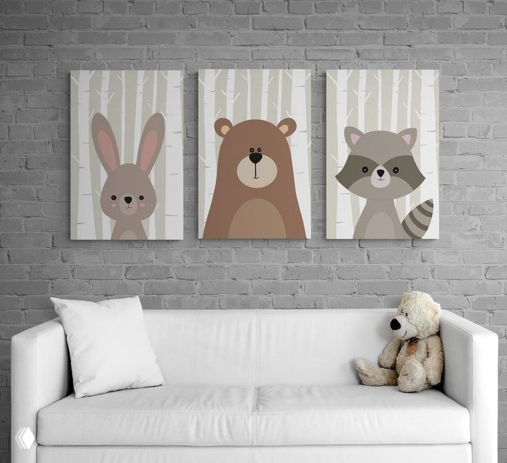 Три панно с изображениями зайца, медведя и енота на кирпичной стене над белым диваном — спокойная нейтральная гамма для детской.