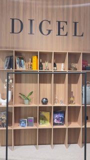 Интерьер магазина DIGEL в Outlet Village Pulkovo: деревянные стеллажи с экспозицией товаров, крупный логотип DIGEL над витриной, уютная брендированная сценография.