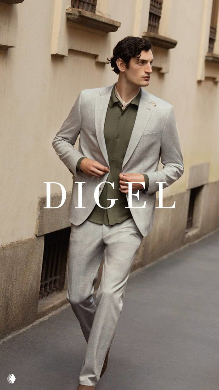 Мужская модель в светло-сером костюме DIGEL идёт по городской улице; фото передаёт идею непринуждённого стиля и практичных силуэтов для повседневности.