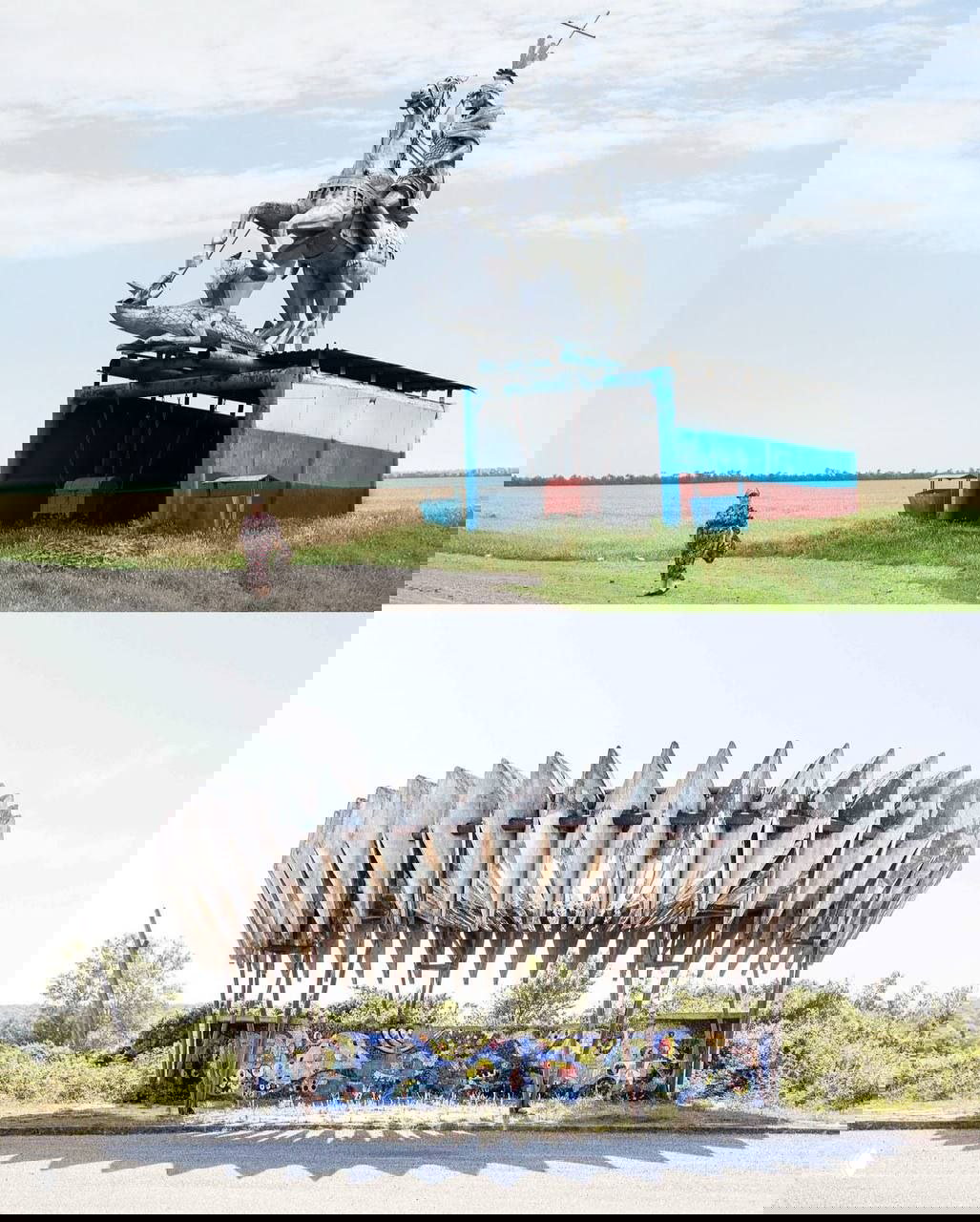 Бетонная остановка со сценой и изображением коровы внутри, пасторальный пейзаж вокруг и деревянный забор на фоне.