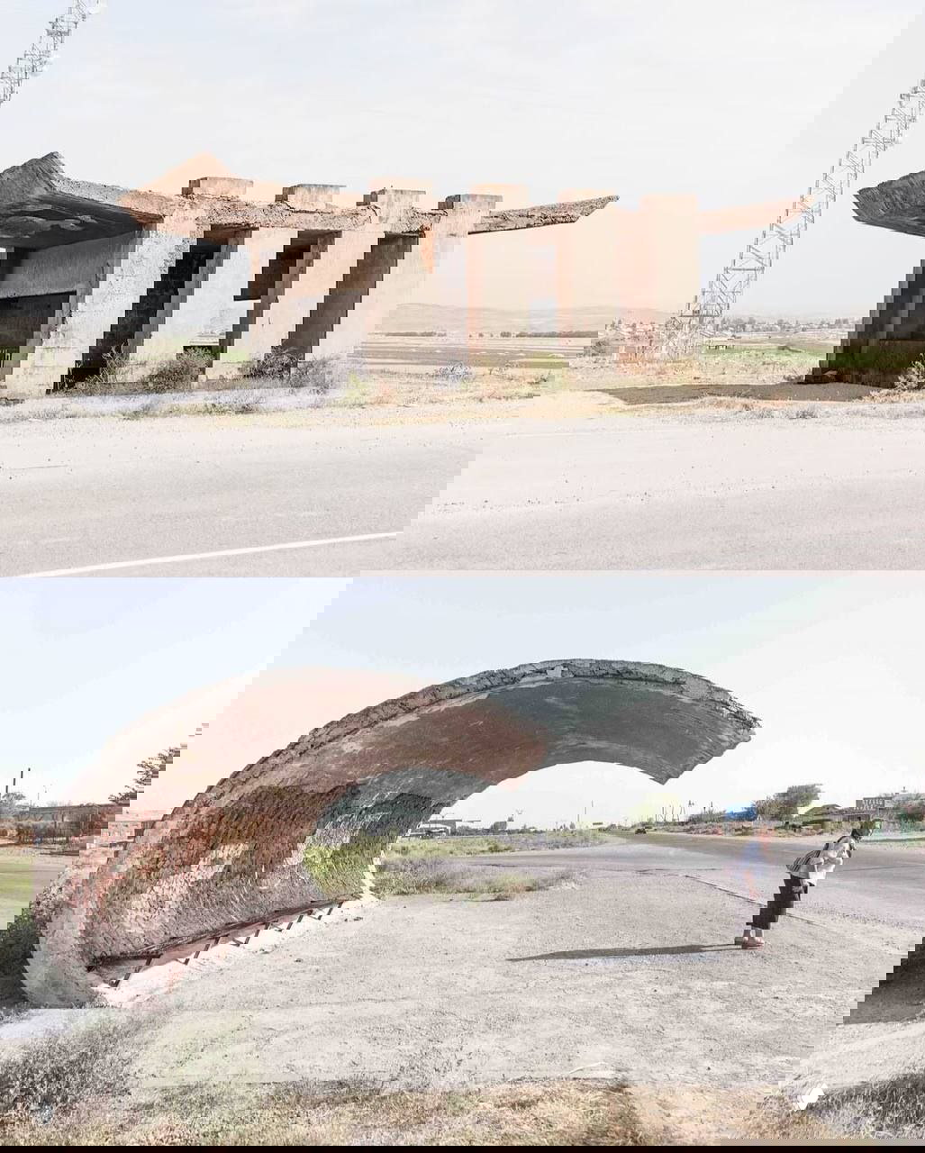 Серые арочные бетонные ниши-остановки на холме, простая конструкция с видом на поле и туманную долину.