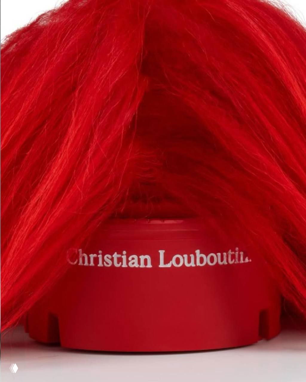 Крупный план задней части подошвы с белой надписью Christian Louboutin, окружённой ярко-красным искусственным мехом, акцент на бренде и отделке.