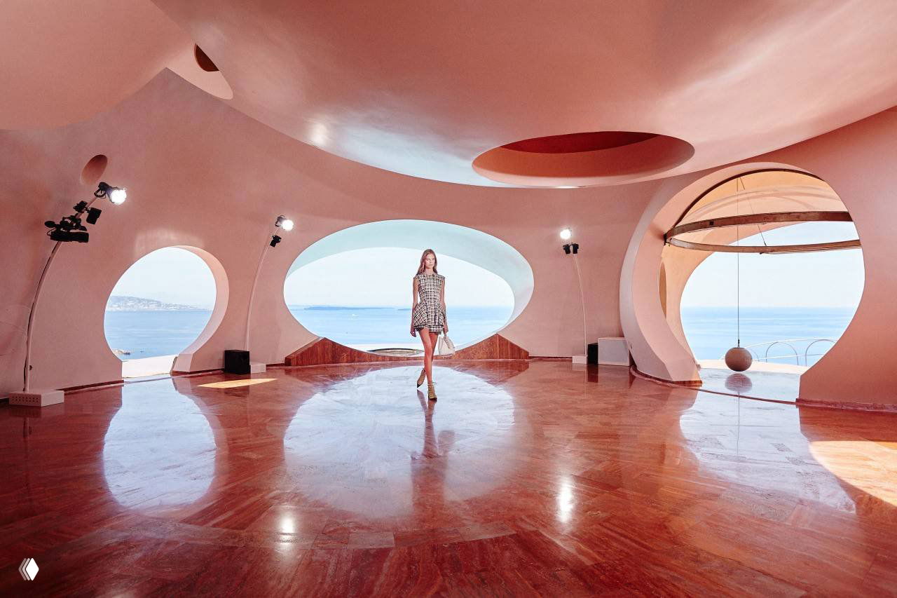 Интерьер пузырчатого дома: просторный зал 70‑х с округлыми окнами и подиумом, вид на море и ретро‑освещение