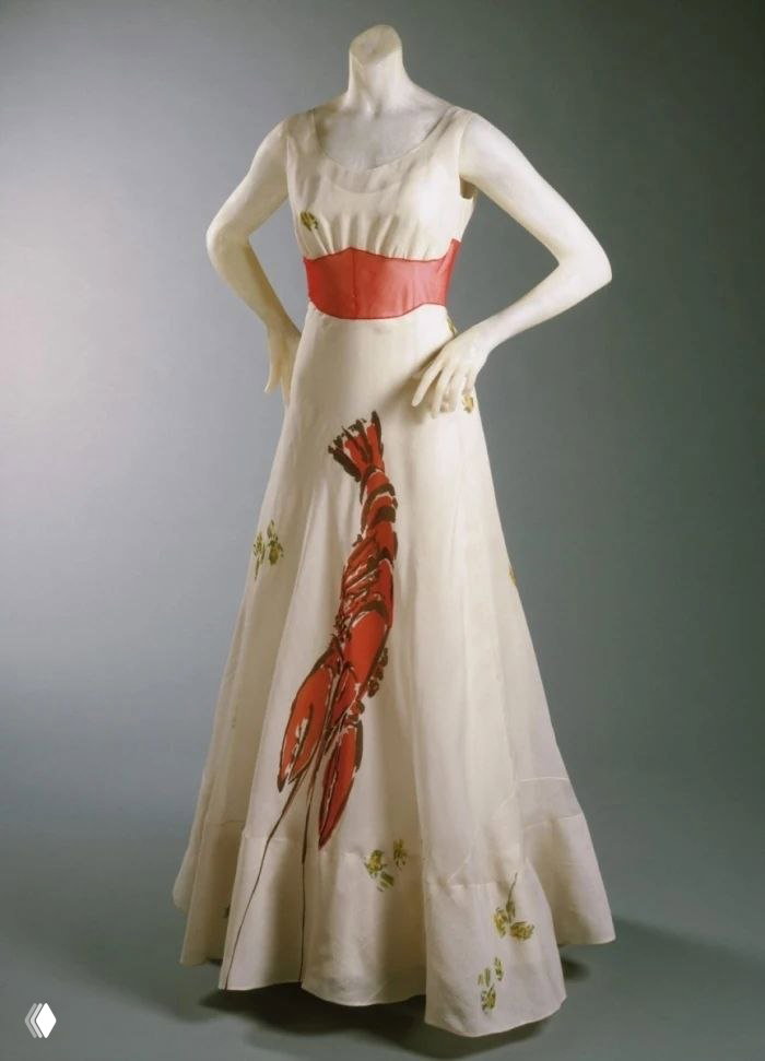 Платье Эльзы Скиапарелли с принтом омара — белое вечернее платье с красным изображением омара и акцентным поясом, в музее.