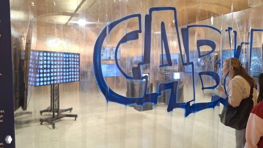 Инсталляция с прозрачными шторками и граффити на них; посетители рассматривают медиа-объект и световую скульптуру за экраном.