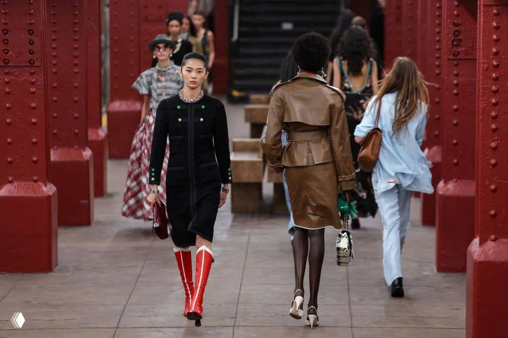 Парад моделей, среди которых черные и светлые силуэты, идет по платформе станции метро — постановка создает эффект реального городского перформанса.