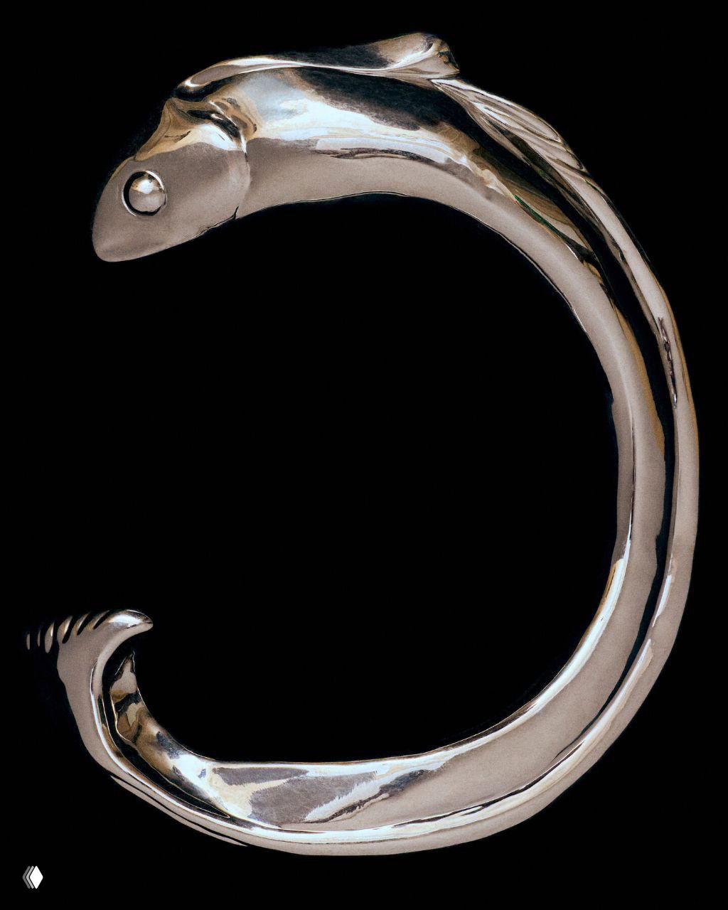 Блестящее металлическое украшение или элемент декора на чёрном фоне, фотография акцентирует форму и отражение поверхности аксессуара.