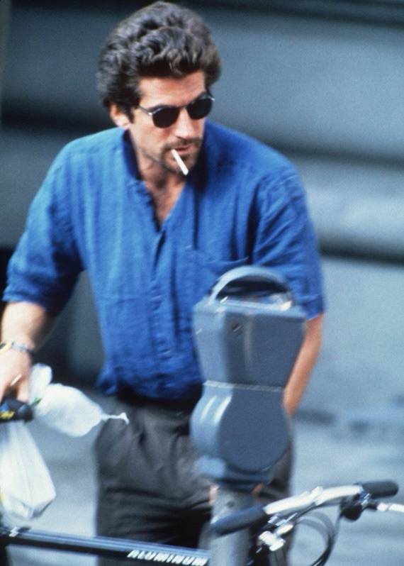 Кадр крупным планом: мужчина в тёмной рубашке и очках идёт рядом с велосипедом, образ подчёркивает сочетание практичности и стиля.