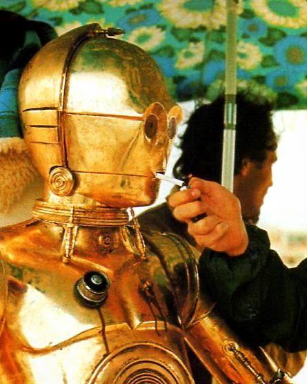 Ретро-фото робота C-3PO со сценической сигаретой в руках — винтажный кинематографический кадр и ироничная отсылка к культуре и образам.