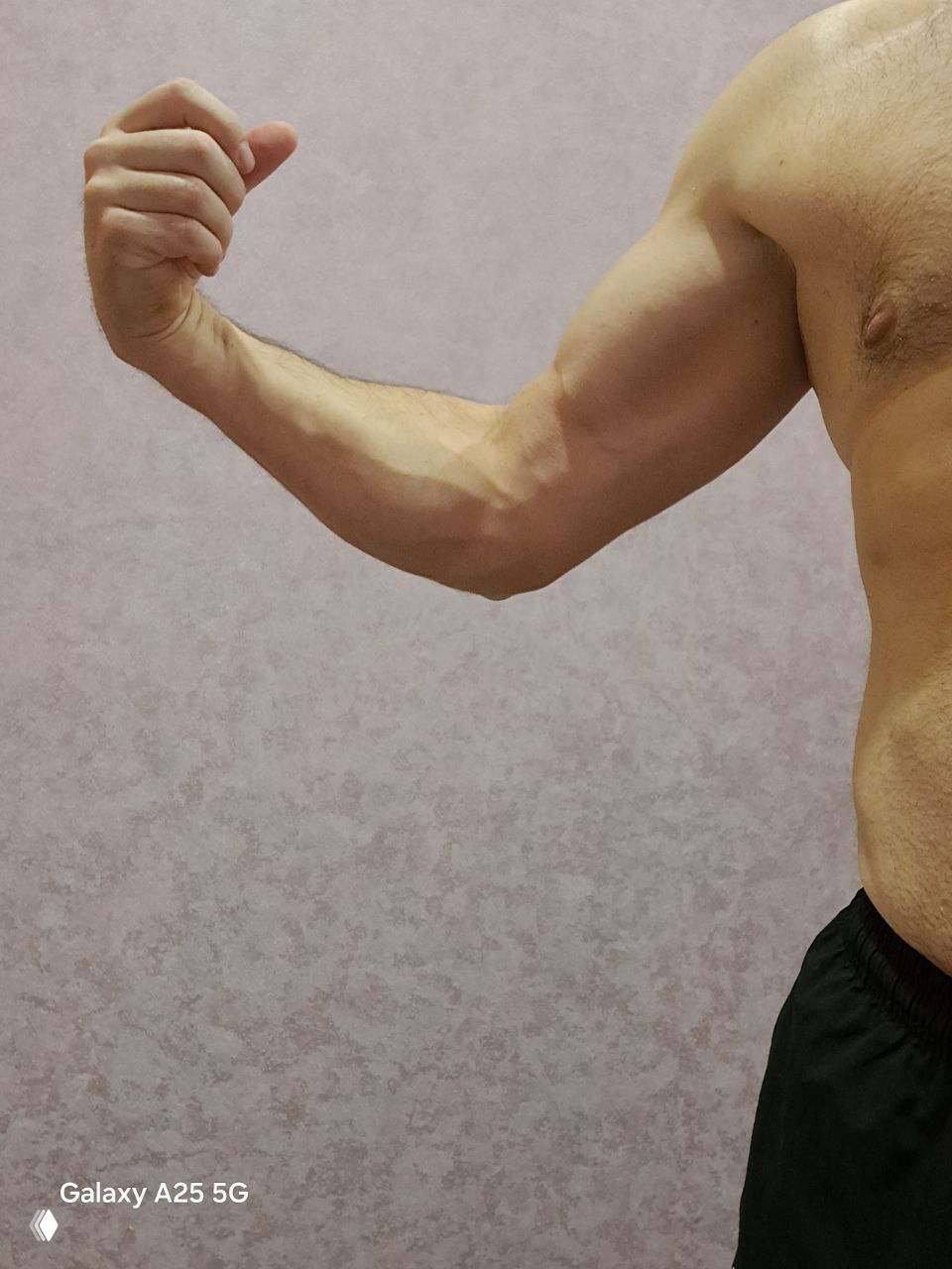 Общий снимок руки и части торса мужчины в позе сгибания, где видна венозность и относительная диспропорция между руками и корпусом.