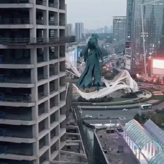 Аэрофотосъёмка масштабной голограммы в форме фигуры, напоминающей дементора, установленной в районе Луцзяцзуй в Шанхае; вокруг небоскрёбы и городской пейзаж.