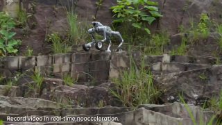 Робот‑собака Unitree Super Athlete AS2‑W на каменистом склоне в демонстрационном кадре; видно, как машина удерживает равновесие и поднимается по неровной поверхности.