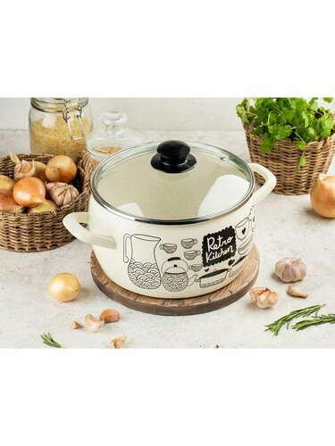 Эмалированная кастрюля кремового цвета с крышкой на кухонном столе: рядом лук, зелень и специи, уютная сцена приготовления пищи.