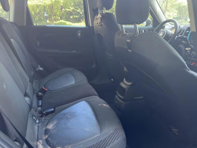 Интерьер заднего ряда зелёного MINI Countryman 2019: два посадочных места, тканевые сиденья, состояние салона видимо обычное для эксплуатации