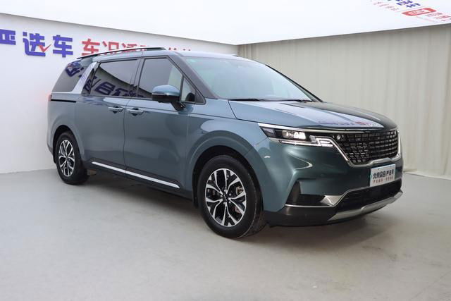 Kia Carnival (март 2025) — вид спереди под другим углом, демонстрирует дизайн бампера, фары и линию капота в шоуруме.