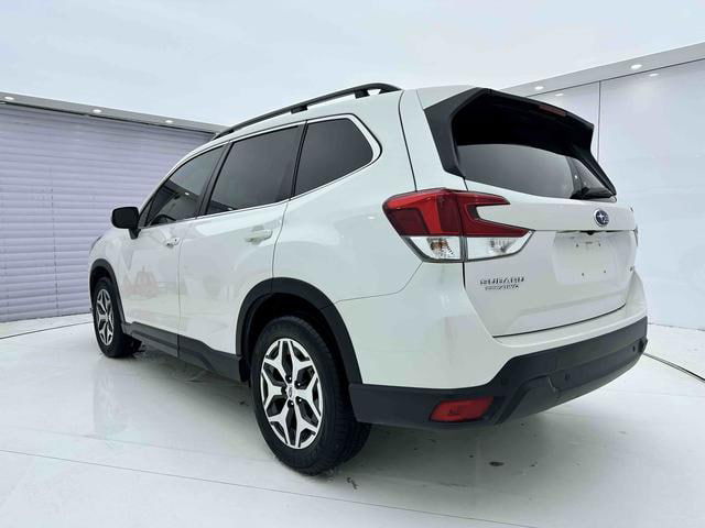 Белый Subaru Forester 2022, вид сзади‑справа в студии: кормовая часть, фонари, багажник и общая пропорция кузова автомобиля