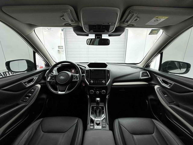 Интерьер Subaru Forester 2022: панель приборов, руль, мультимедиа и центральная консоль, чёрная отделка салона видно чётко