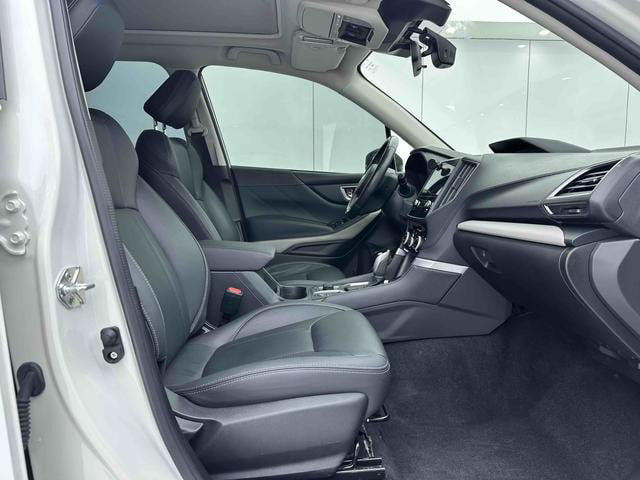 Передние сиденья и пассажирская часть салона Subaru Forester 2022, чёрная обивка, простор у ног и состояние передней части салона