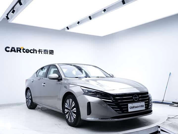 Ниссан Altima (Teana) 2023 крупным планом спереди: решетка радиатора, фары и декоративные элементы кузова на светлом фоне.