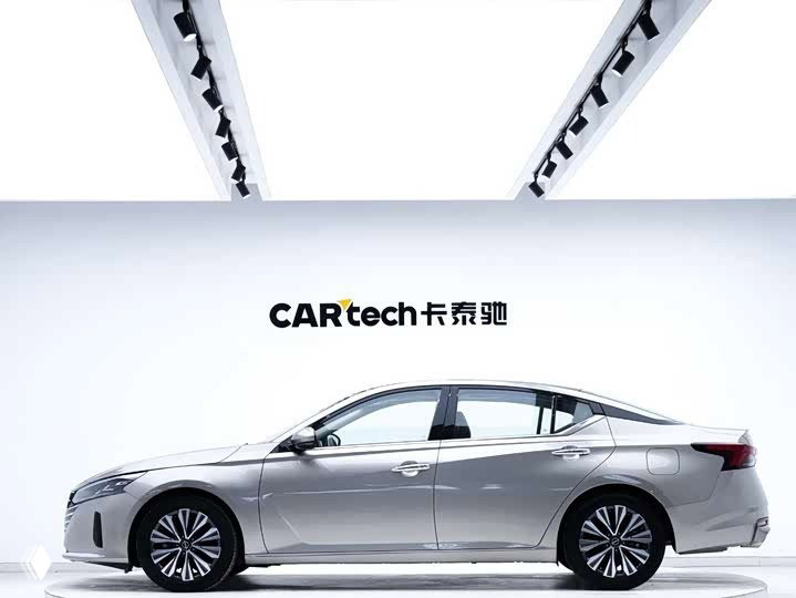 Профиль Nissan Altima (Teana) 2023 в студии: серебристый кузов, элегантная линия крыши и литые диски на светлом фоне дилерской площадки.