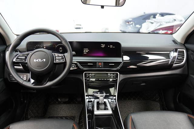 Интерьер Kia Seltos: торпедо, мультимедиа-дисплей и руль; видна современная центральная консоль и материалы отделки салона.