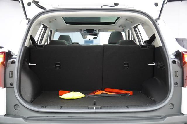 Багажное отделение белого Kia Seltos с поднятой крышкой; видно объём багажника, коврики и предметы внутри для ориентира вместимости.