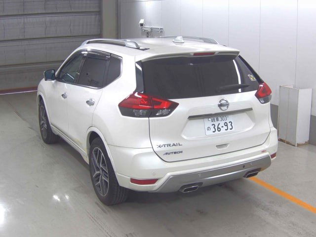 Белый Nissan X‑Trail Autech, вид сзади в паркинге — багажник, задние фонари, шильдики X‑TRAIL и номерная пластина видны отчётливо.