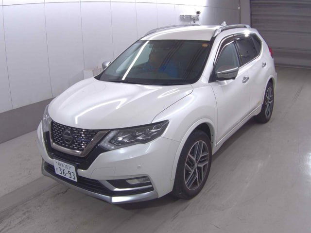 Белый Nissan X‑Trail Autech 2021, три четверти спереди слева в крытой парковке — капот, рейлинги на крыше, линия кузова и диски хорошо читаются.