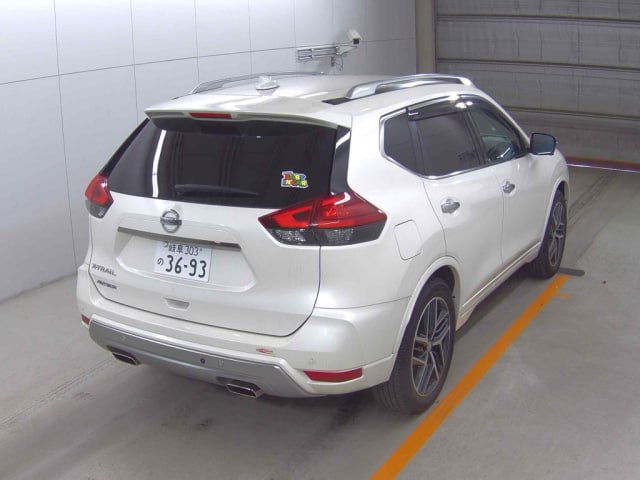 Белый Nissan X‑Trail Autech 2021, три четверти вид сзади в паркинге — фонари, бампер, наклейка на стекле и общий вид багажной части автомобиля.