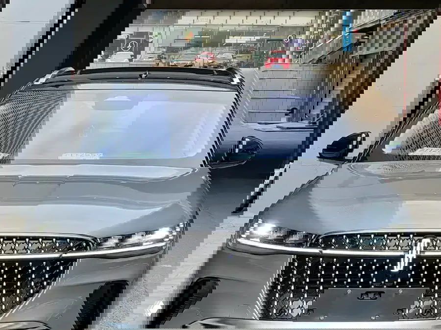 Крупный план передней части Lincoln Nautilus II: светодиодные фары и вертикальная фирменная решётка с эмблемой Lincoln, серый кузов