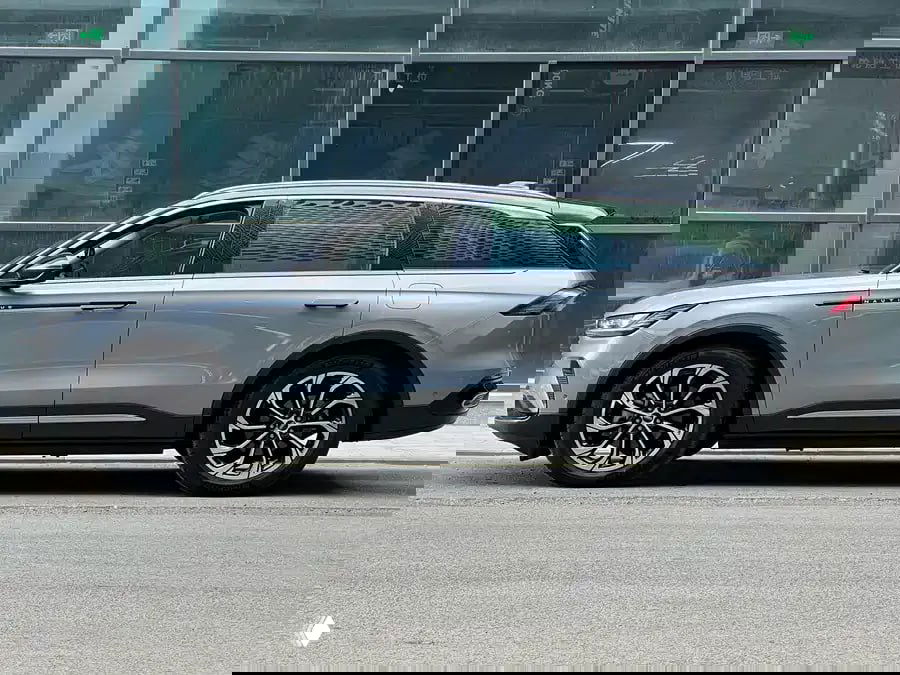 Боковой профиль Lincoln Nautilus II 2023: силуэт внедорожника, четырехдверная компоновка и дизайн дисков на фоне городской застройки