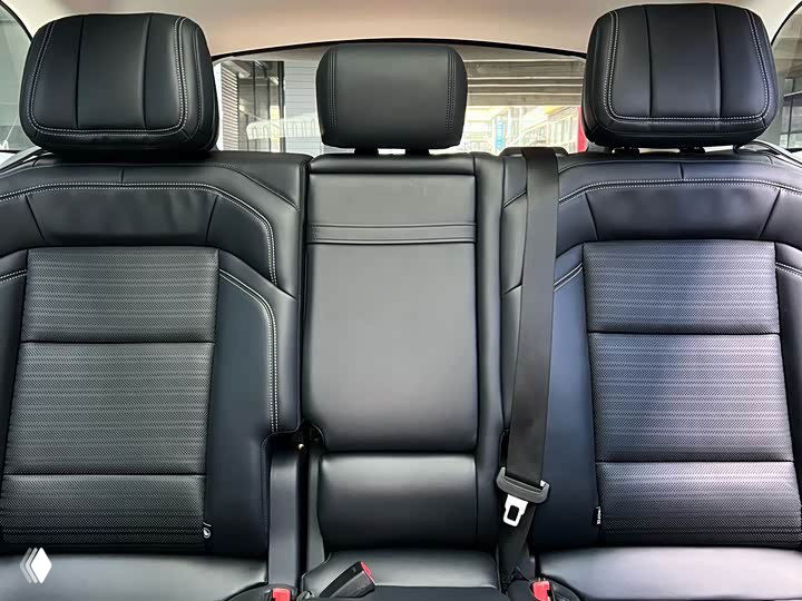 Задние сиденья Lincoln Nautilus II: чёрная обивка, трёхместный диван и вид на ремни безопасности, аккуратная отделка салона