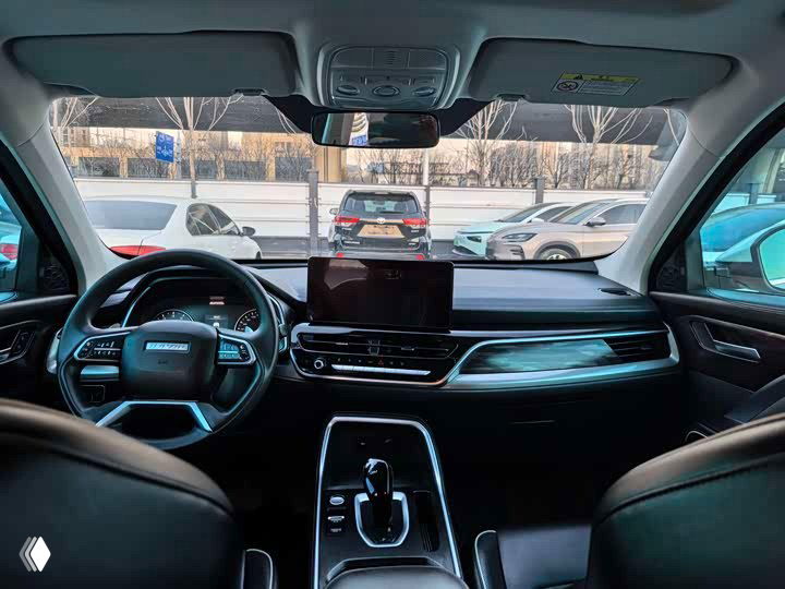 Интерьер Haval H6: центральная консоль, мультимедийный экран и селектор коробки передач, общий вид передней части салона.