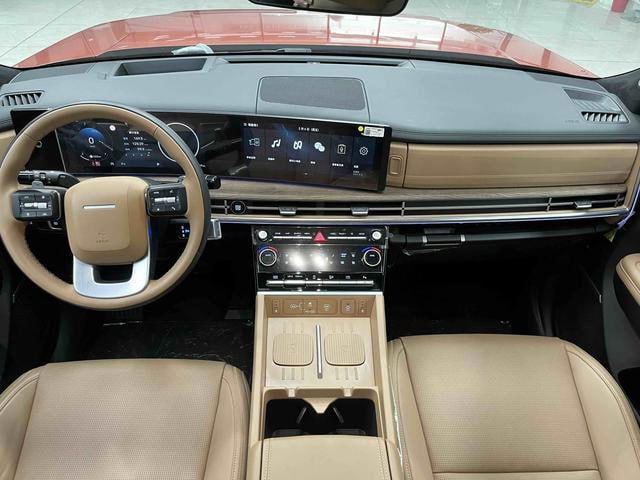 Салон Hyundai Santa Fe 2024: торпедо с крупным центральным экраном, панелью приборов и коричнево‑бежевой отделкой изнутри в дилерском образце.