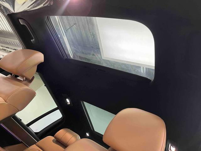 Панорамная крыша и задняя часть салона Hyundai Santa Fe 2024 с обзором люка и светлых сидений, вид сверху‑внутри.