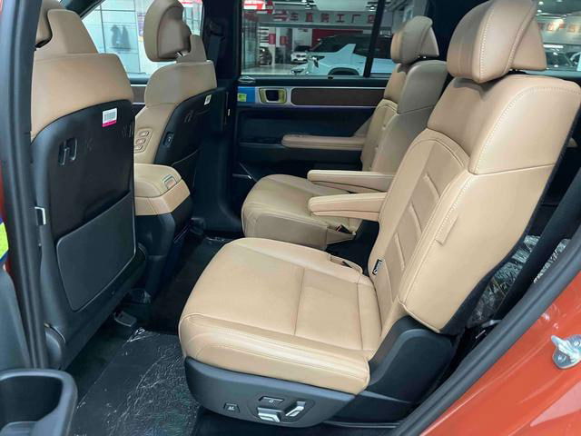 Задние сиденья Hyundai Santa Fe 2024 в тёмно‑бежевой отделке, два отдельных кресла второго ряда с подлокотниками и просторным проходом в салоне.