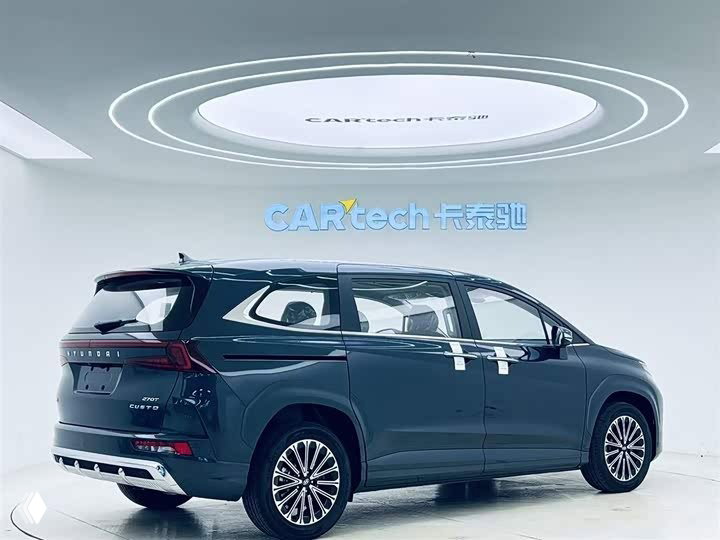 Hyundai Custo 2025 — вид сзади под углом в выставочном зале: видна задняя оптика, багажник, бампер и контуры кузова.