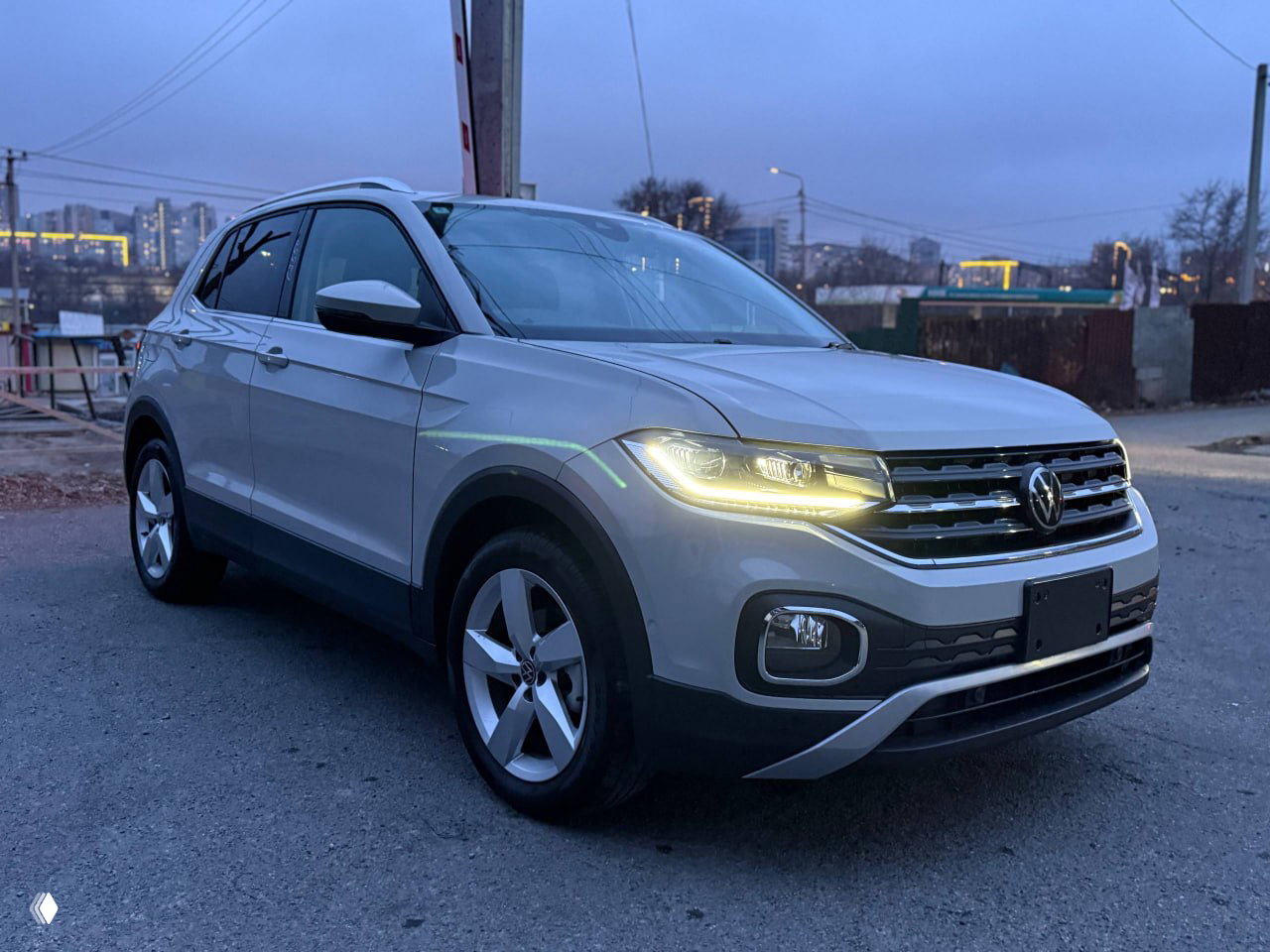 Прямой вид сзади на Volkswagen T‑Cross: номерная рамка, фонари и состояние заднего бампера, фотография сделана на открытой стоянке во Владивостоке.