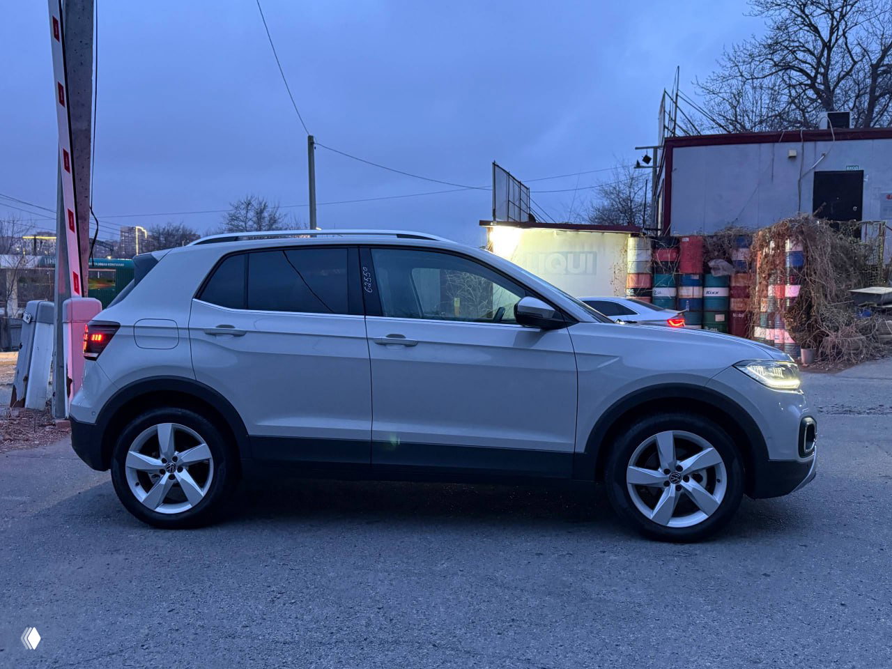 Открытый багажник Volkswagen T‑Cross 2023 года: вид на нишу груза, чистое полотно пола багажника и складные спинки сидений, без посторонних предметов.