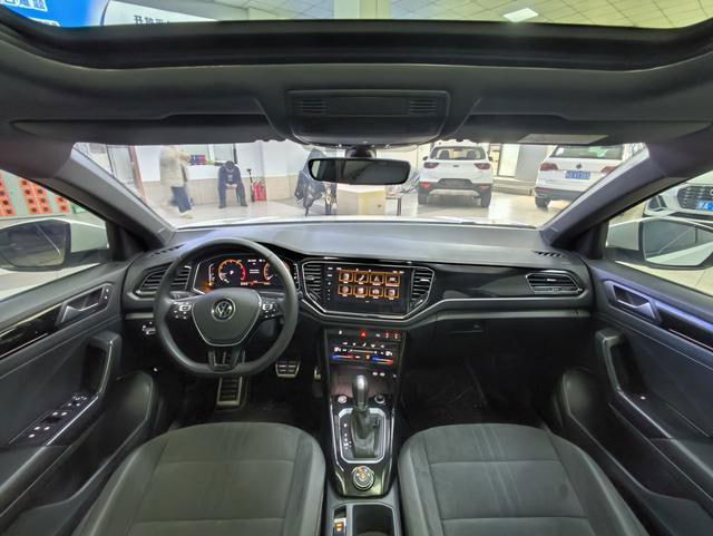 Интерьер Volkswagen T‑Roc 2021: панель приборов, руль, передние сиденья и мультимедиа; фото для оценки комплектации и состояния салона.