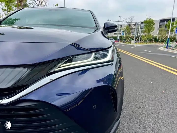 Крупный план передней фары Toyota Harrier 2022 года, подчёркнуты светодиодные элементы и лакокрасочное покрытие тёмно-синего цвета.
