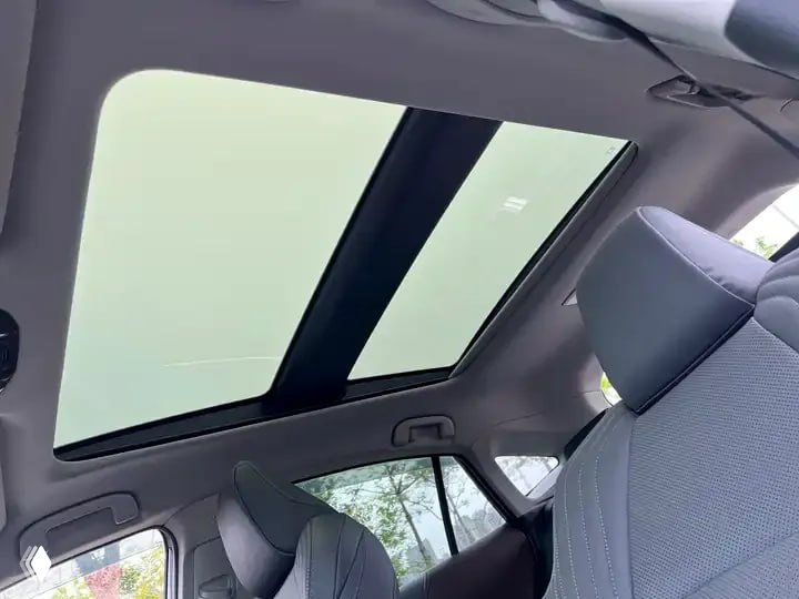 Вид салона Toyota Harrier сверху: панорамная крыша, передние сиденья и светлая обивка — интерьер в дневном свете без посторонних предметов.