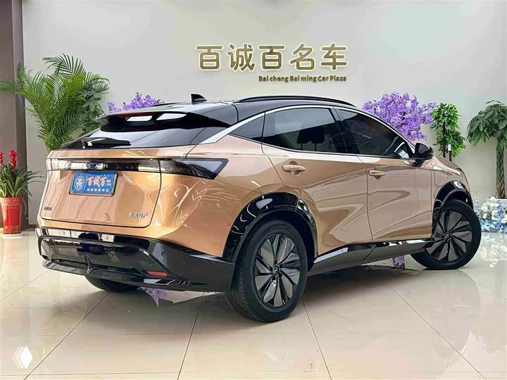 Задняя трёхчетвертная проекция Nissan Ariya в салоне: видна форма кормы, задние фонари и общий объём кузова в шоурум‑обстановке.