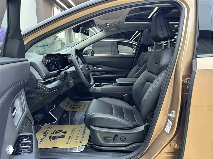 Водительская дверь открыта: обзор салона Nissan Ariya, чёрные тканевые или кожаные сиденья, электроприводы регулировки и аккуратная отделка.