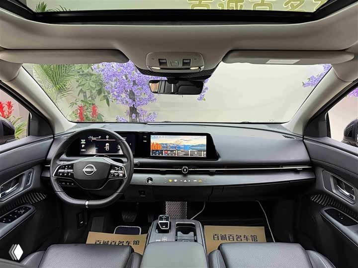 Панель приборов и медиасистема Nissan Ariya: широкий экран информационно‑развлекательной системы, мультируль и обзор передней части салона.