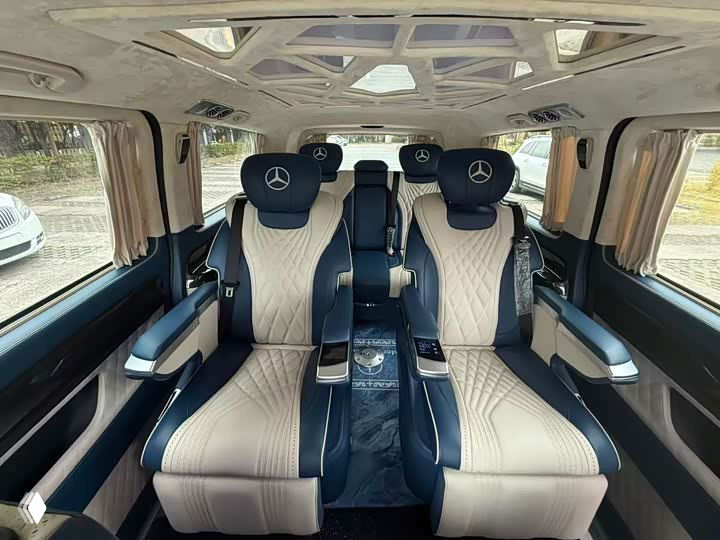 Задний салон Mercedes‑Benz Vito: два роскошных раскладных кресла с бело‑синей обивкой, подлокотники и панорамная часть крыши в салоне.