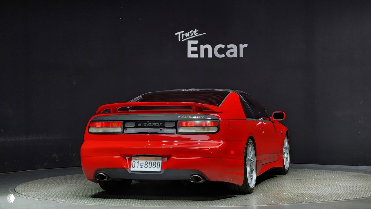 Ещё один ракурс сзади красного Nissan 300ZX Z32 на поворотной площадке, отчетливо видны задние фонари и номерной знак автомобиля.