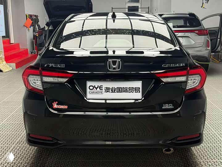 Крупный план задней части Honda Crider 2021: эмблема, светотехника и наклейки дилера; багажная крышка и бампер в хорошем состоянии без видимых повреждений.