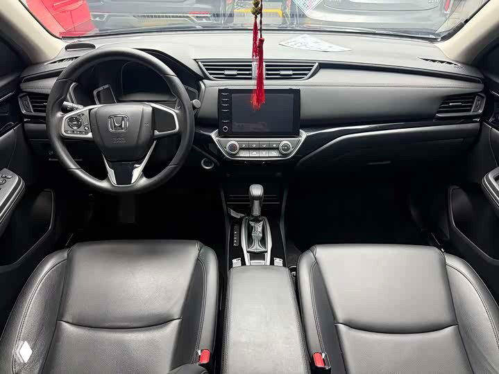 Салон Honda Crider 2021: вид на руль, центральную консоль, коробку передач и передние сиденья — чёрная обивка, аккуратное состояние, экран мультимедиа виден.