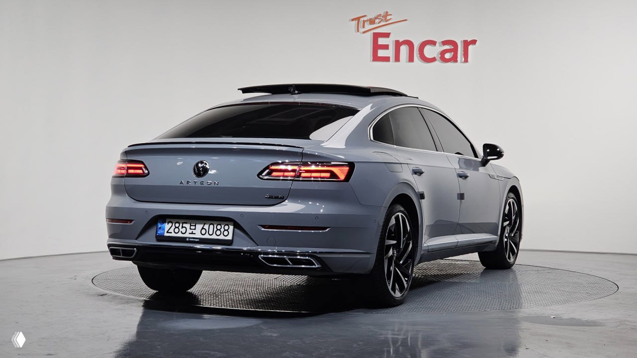 Вид сзади и боковой профиль Volkswagen Arteon 2022 в шоуруме Encar; хорошо видны задние фонари, выхлопные патрубки и корейский госномер.